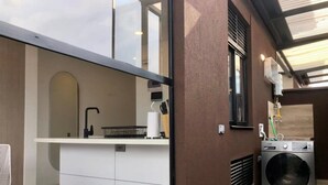 A compact kitchen with a built-in stove, a sink, and a washing machine. - Splendid Loft With Terrace in Laureles (Medellín)