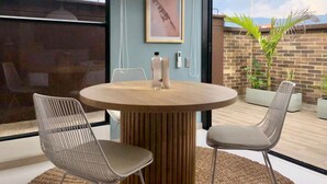 A round table with two chairs, a pendant light, a framed picture, and a small plant. - Splendid Loft With Terrace in Laureles (Medellín)