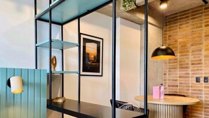 A modern interior with a black metal desk, a round wooden table, and a brick wall. - w Astounding Loft in Virrey (Bogotá)