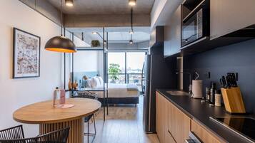 Una cocina moderna con una mesa de comedor de madera, sillas negras y una encimera negra.
