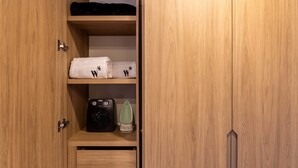 A wooden wardrobe with two shelves, a hanging space, and a drawer.