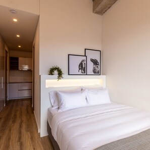 A bedroom with a bed, a headboard, and two framed pictures on the wall. - w Modern Loft in Chapinero (Bogotá)