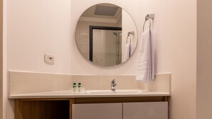 A bathroom with a round mirror, a sink, and a towel rack. - w Modern Loft in Chapinero (Bogotá)