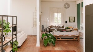A spacious living area with a white sofa, a wooden coffee table, and a large plant. - w Astonishing Casa Centenario in Barranco (Lima)