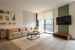 A modern living room with a sofa, coffee table, and a flat-screen TV. - w Unique 2BR With Balcony in Miraflores (Lima)