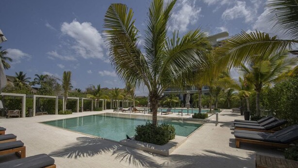 A pool area with lounge chairs and palm trees. - w Fantastic 2BR w AC in Sunny Cartagena (Cartagena)