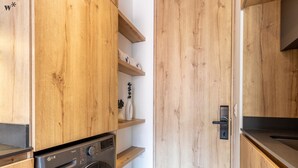 A compact kitchen with wooden cabinetry, a built-in washing machine, and a small countertop. - Amazing Loft With Balcony in El Nogal (Bogotá)