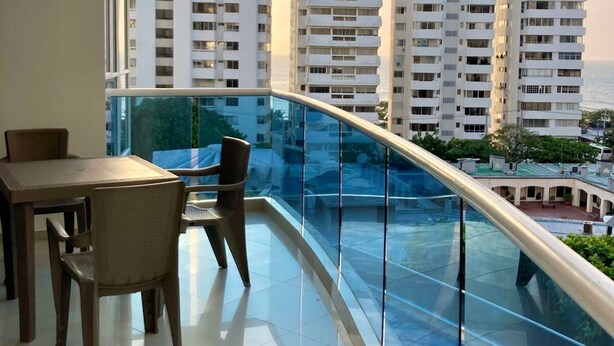 A balcony with a glass railing overlooking a cityscape. - w Oceanview 2BR w/ Terrace n AC in El Laguito (Cartagena)