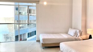 A modern hotel room with a large balcony, a bed, and a bedside table. - w Oceanview 2BR w/ Terrace n AC in El Laguito (Cartagena)