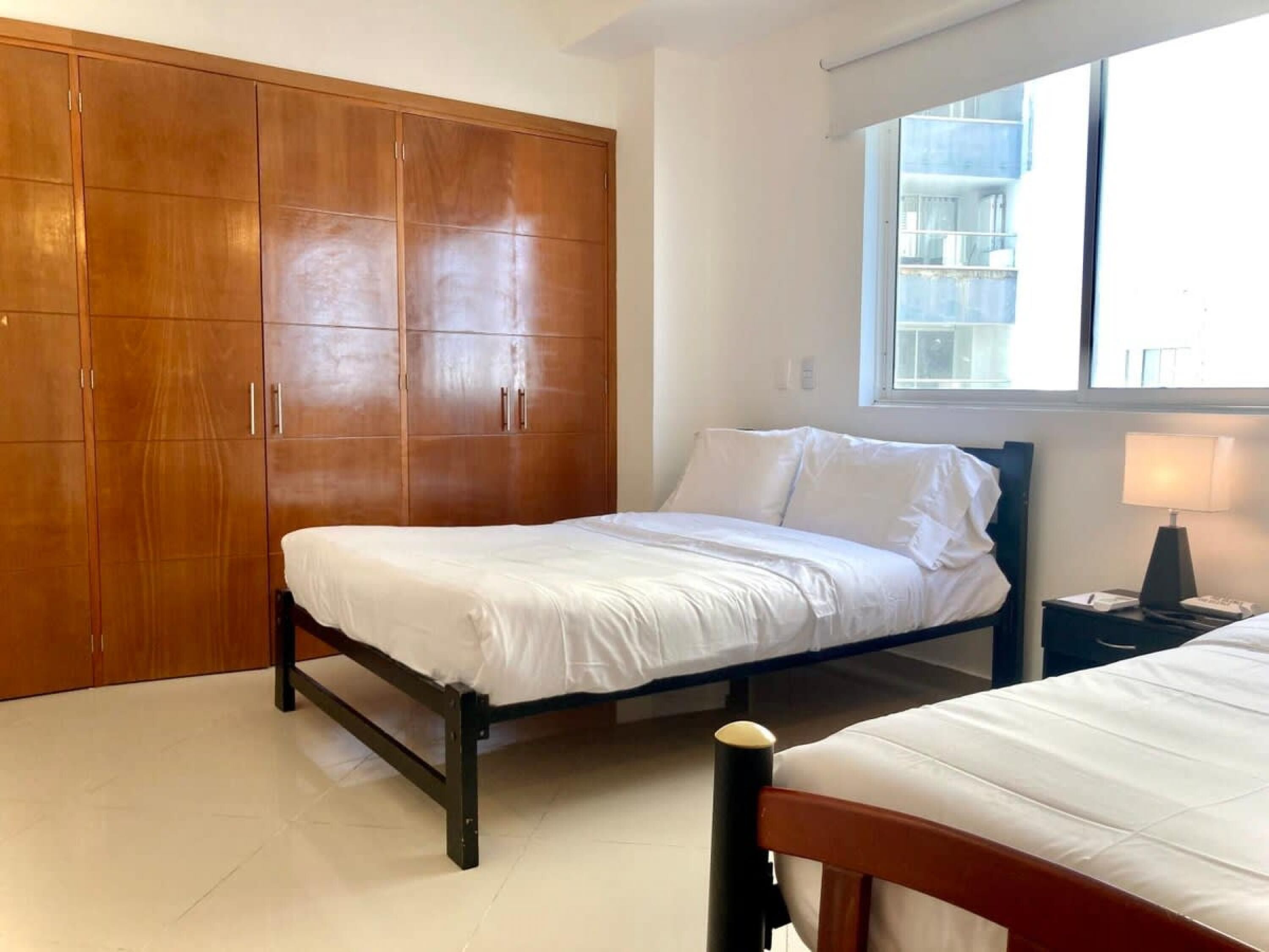 A bedroom with a bed, a wardrobe, and a window.