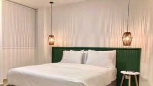 A modern bedroom with a large bed, green headboard, and two pendant lights. - w Spectacular 2BR Apartment w/ AC in Cartagena (Cartagena)