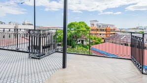 Terraza en la azotea con pérgola, baranda de metal y suelo estampado.