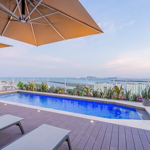 Une piscine sur le toit offrant une vue sur la ville et la mer.