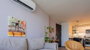 Un soggiorno moderno con un divano grigio, un tavolino in legno e un telecomando sopra.
