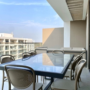 A modern balcony with a glass table and wicker chairs, overlooking a cityscape. - w Amazing 2BR With Balcony in Cartagena (Cartagena)