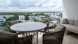 En balkon med fletmøbler, et rundt bord og en sofa.