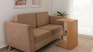A modern living room with a beige sofa, a small wooden coffee table, and two framed artworks on the wall. - w Spectacular 1BR With Terrace at Poblado (Medellín)