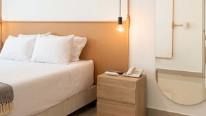 A neatly arranged bedroom with a bed, bedside table, and a mirror. - w Spectacular 1BR With Terrace at Poblado (Medellín)