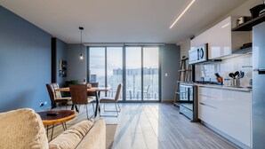 En moderne lejlighed med opholdsstue, spiseplads og køkken.