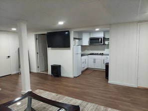A modern kitchen with white cabinets, a microwave, and a stove. - Studio by Dane & Dianne (College Park)
