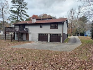 A two-story house with a front porch, two garages, and a covered driveway. - Studio by Dane & Dianne (College Park)