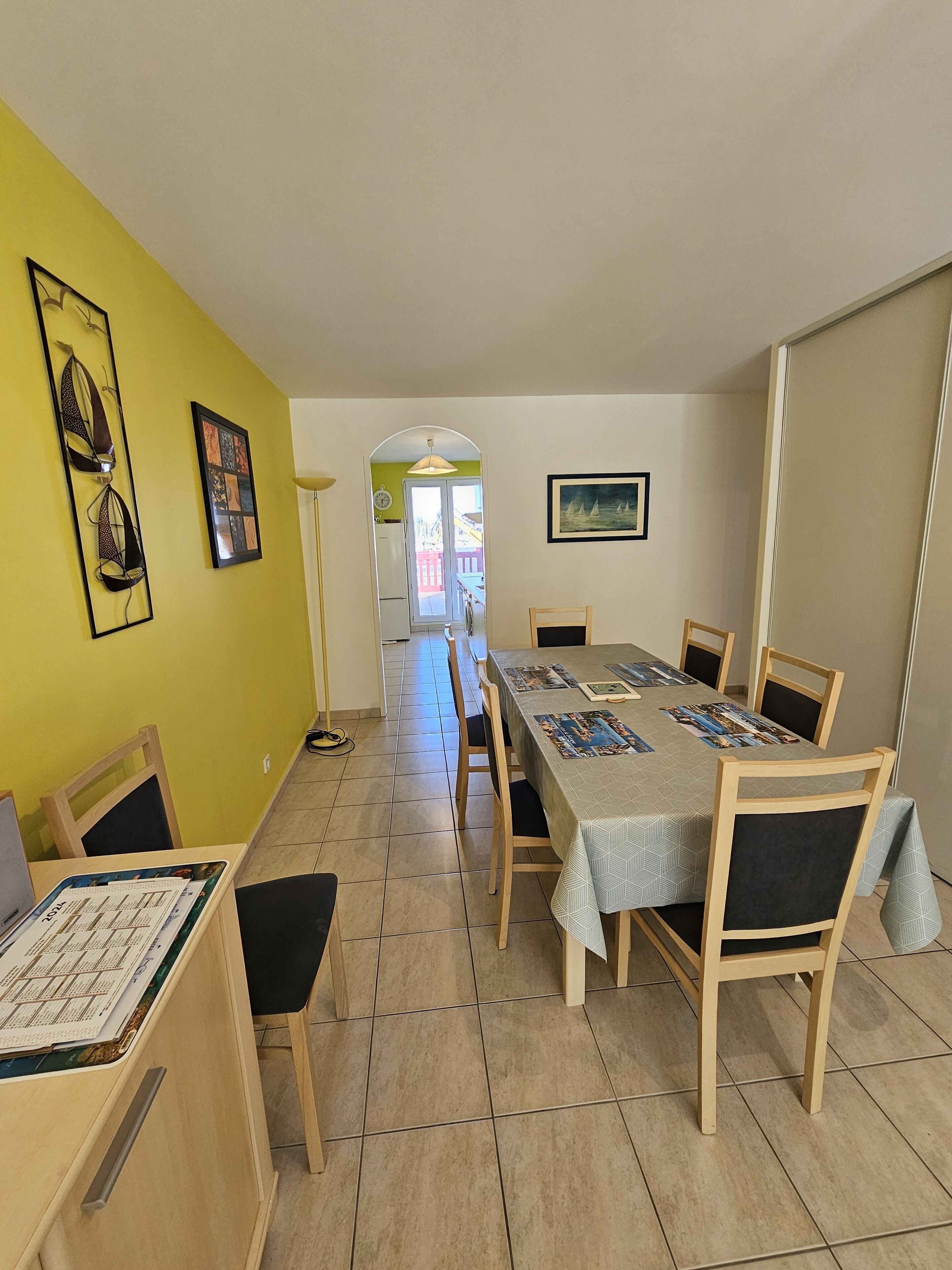 Comedor con una mesa larga, sillas y vistas al exterior a través de un arco.