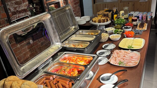 A buffet with various food items and utensils. - Iris Aparthotel (Kraków)