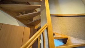 A wooden spiral staircase with a handrail, leading to an upper floor. - Iris Aparthotel (Kraków)