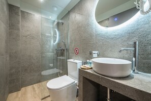 A modern bathroom with a glass-enclosed shower, a white toilet, a sink with a mirror, and a no-entry sign on the wall. - Aeiphoria Suites & Rooms - Athens (Athens)