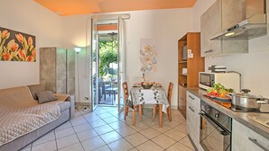 Um espaço compacto com área de jantar, cozinha compacta e sofá.