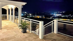 Un balcon donnant sur une vue panoramique de la ville la nuit.