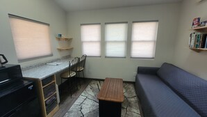 A compact living space with a kitchenette, a dining area, and a seating area with a sofa. - Tiny Treehouse Cabin | Bluff Woodlands #1 (Elba)