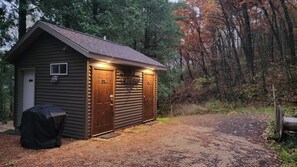 A small wooden cabin with a sloped roof, a door, and a window.
