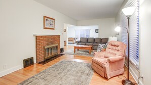 Una sala de estar con chimenea, un sofá, un sillón y una lámpara.