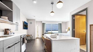 A modern kitchen with a central island, built-in appliances, and a view to the outside.