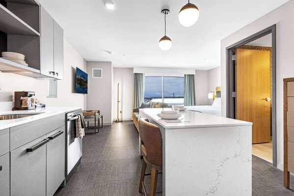 A modern kitchen with a central island, built-in appliances, and a view to the outside. - Homewood Suites By Hilton Colorado Springs Airport (Colorado Springs)