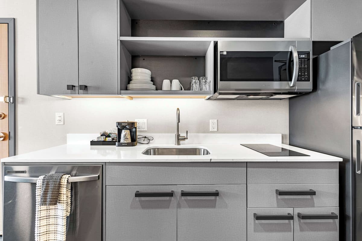 A modern kitchen with a stainless steel refrigerator, a microwave, and a sink.