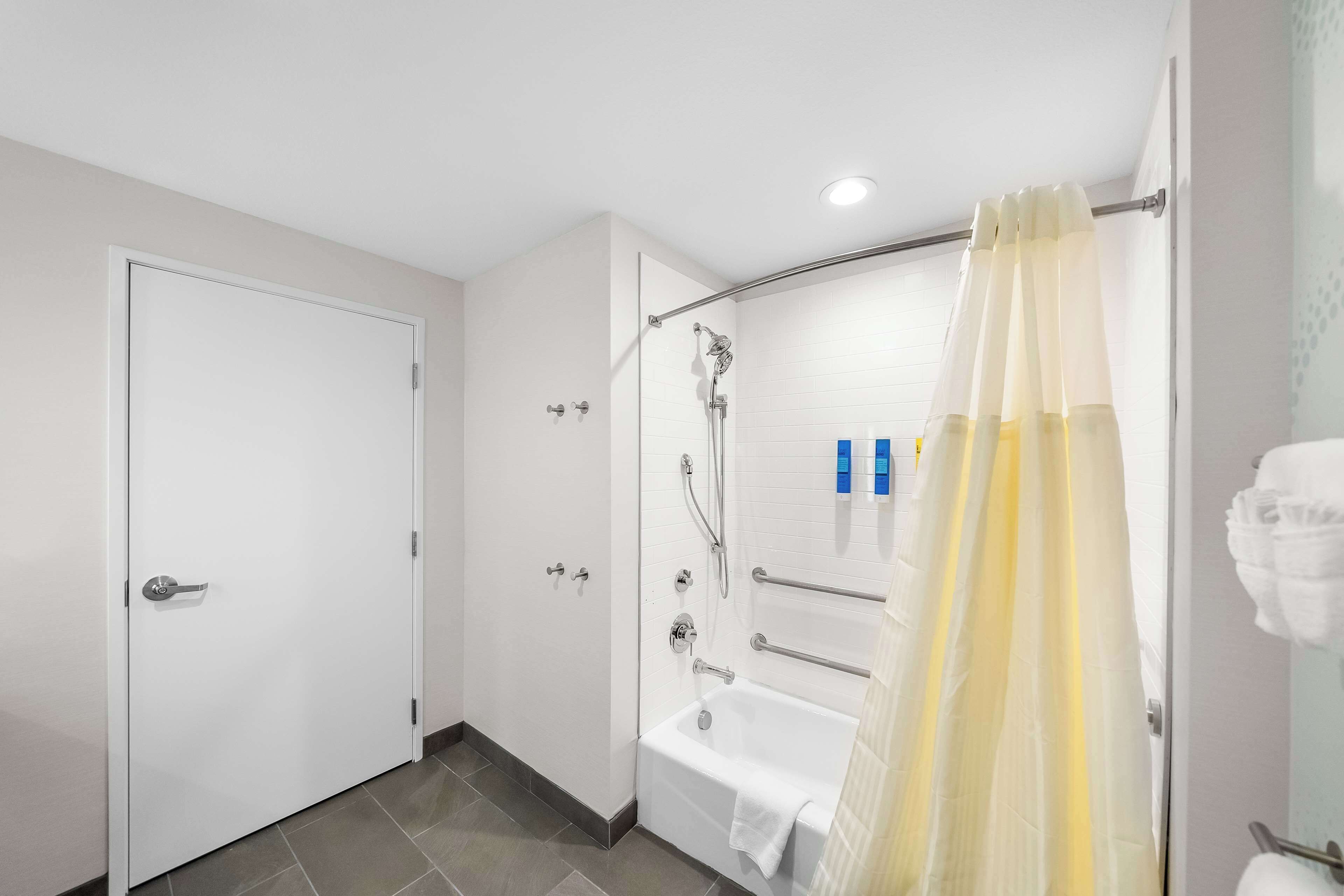 A modern bathroom with a bathtub, shower, and toilet.