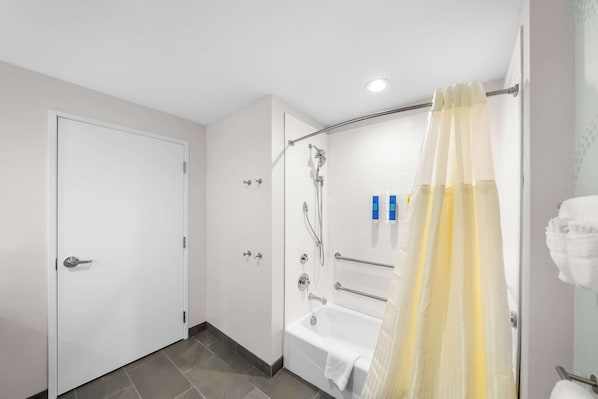 Un baño moderno con bañera, ducha e inodoro.