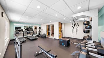 Een sportschool met loopbanden, elliptische trainers en losse gewichten.