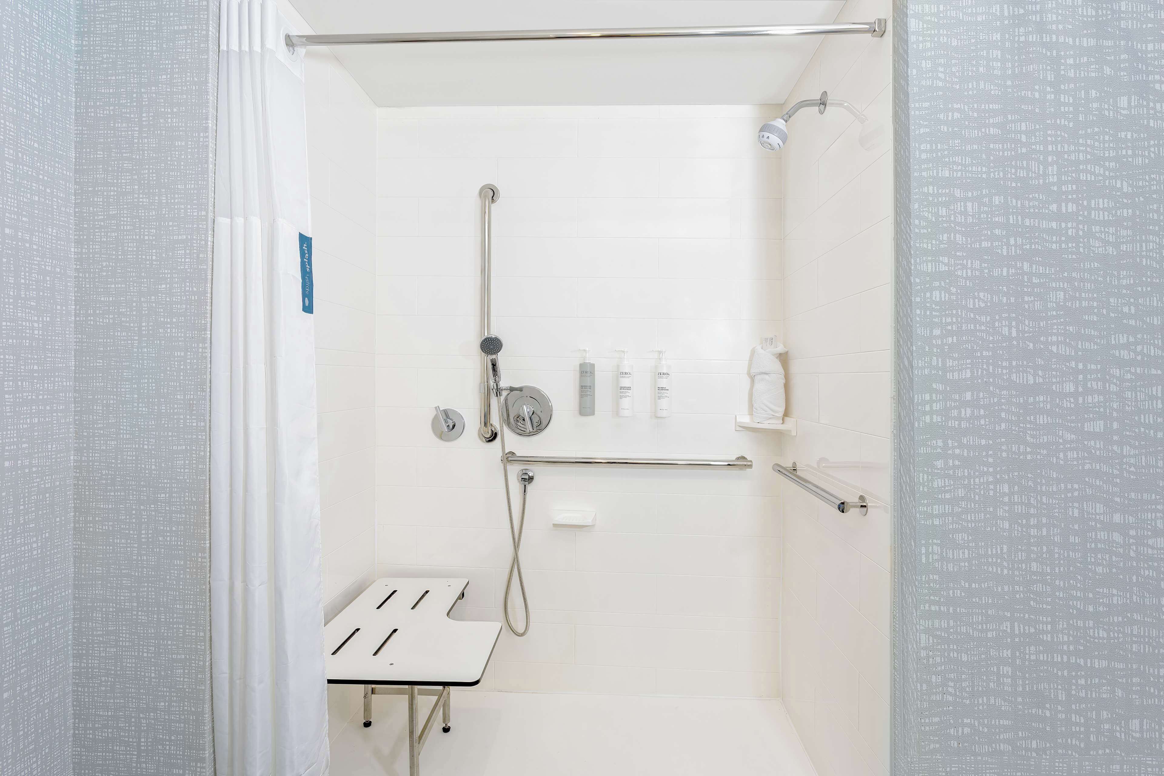 Zona de ducha con cabezal de ducha de mano, un accesorio de ducha manual y un grifo empotrado en la pared.