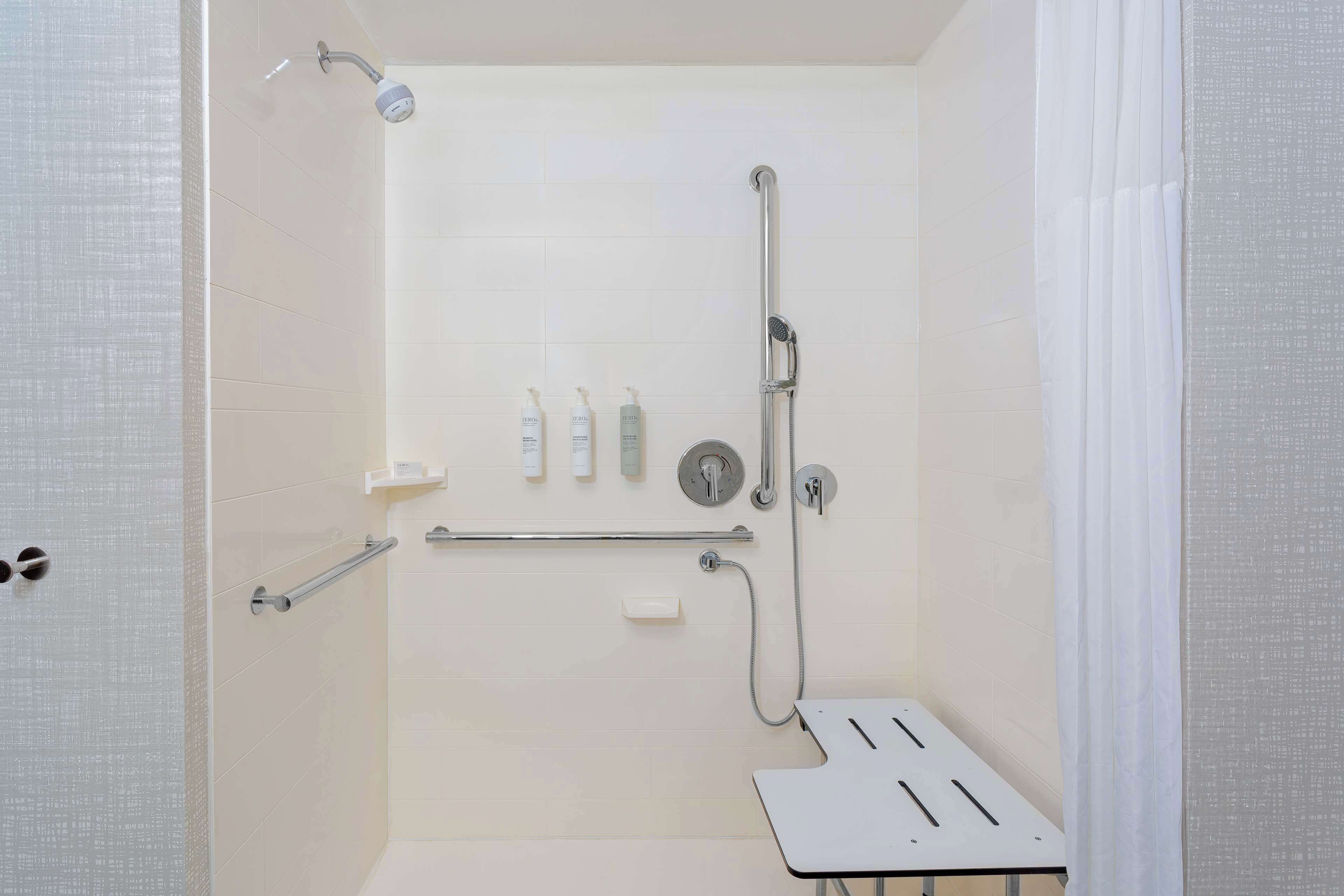 A modern shower area with a handheld showerhead, a wall-mounted faucet, and a handheld shower attachment.