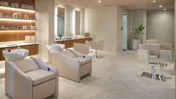 A modern spa with a reception desk, seating area, and a large mirror.