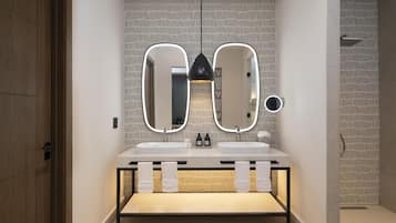 Un baño moderno con dos lavamanos, tocador y espejo con iluminación integrada.