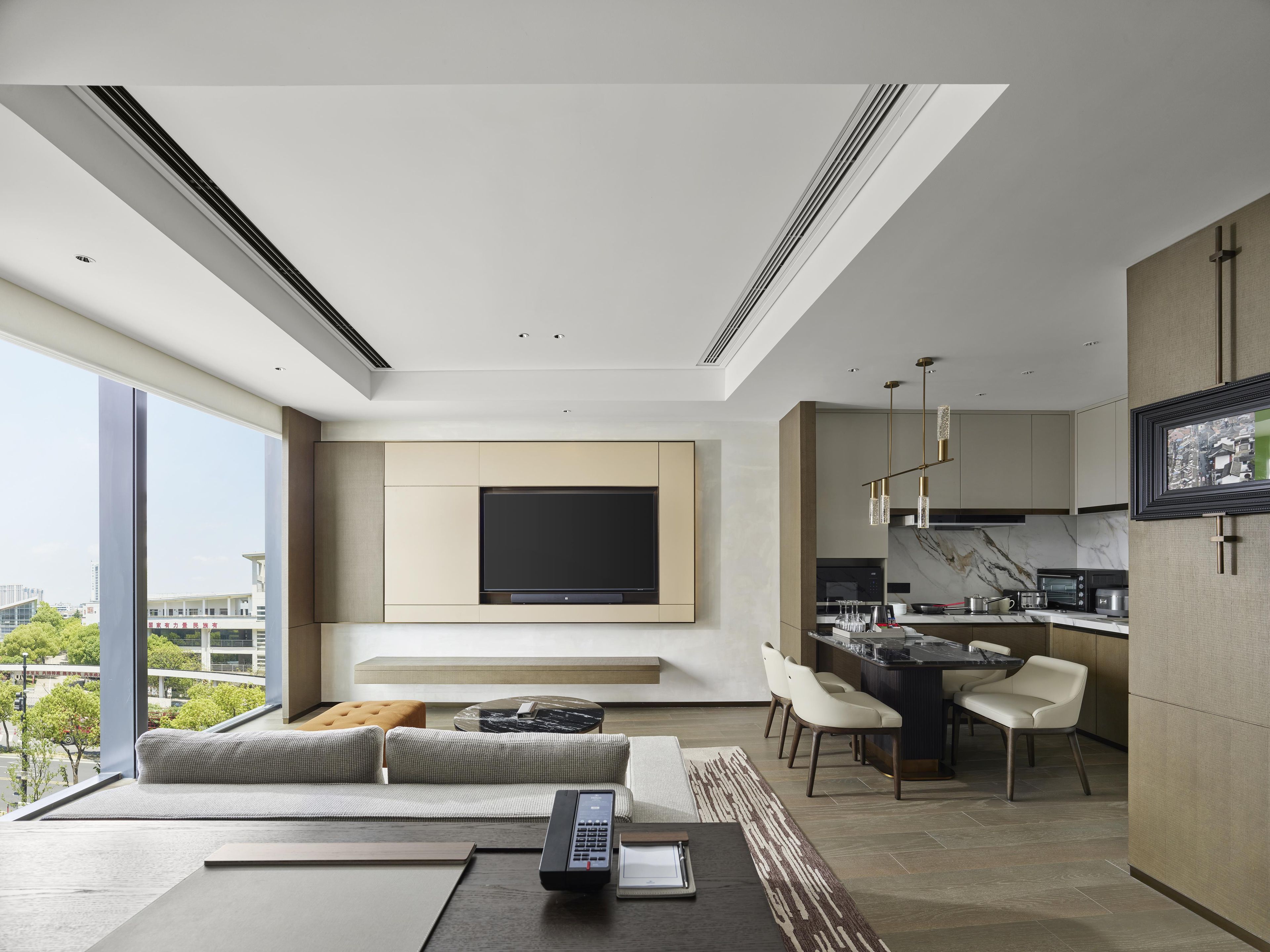 A modern living room with a sofa, a coffee table, and a TV mounted on the wall.