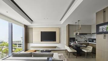 A modern living room with a sofa, a coffee table, and a TV mounted on the wall.