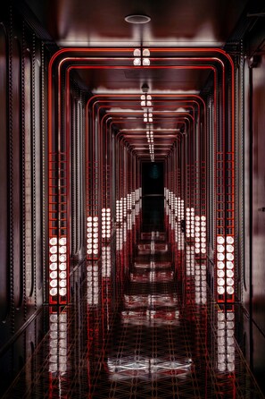 A corridor with a grid of lights and a reflective floor. - Hilton Changshu (Suzhou)