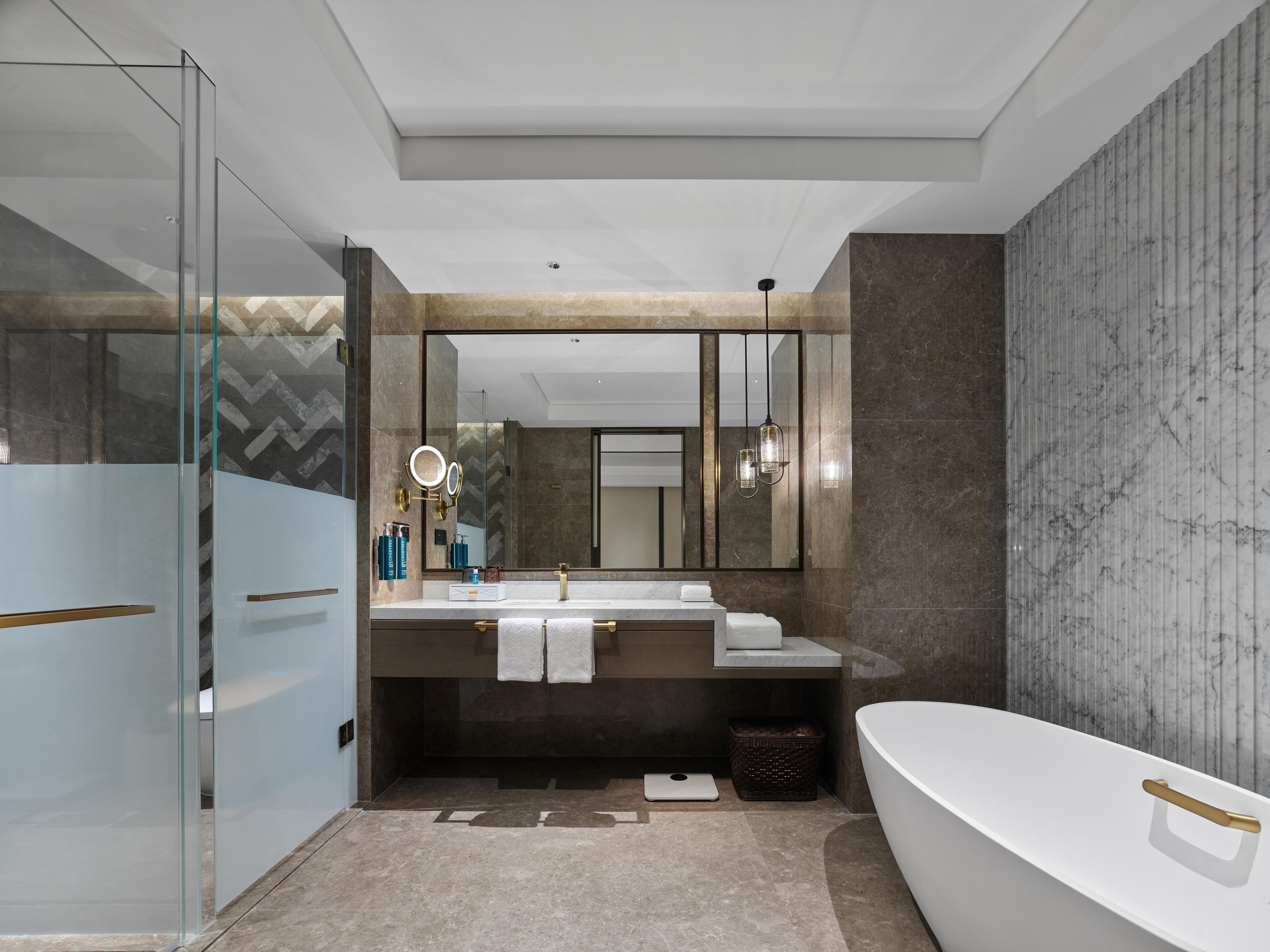 Un baño moderno con una bañera independiente, un espejo grande y un tocador con encimera.