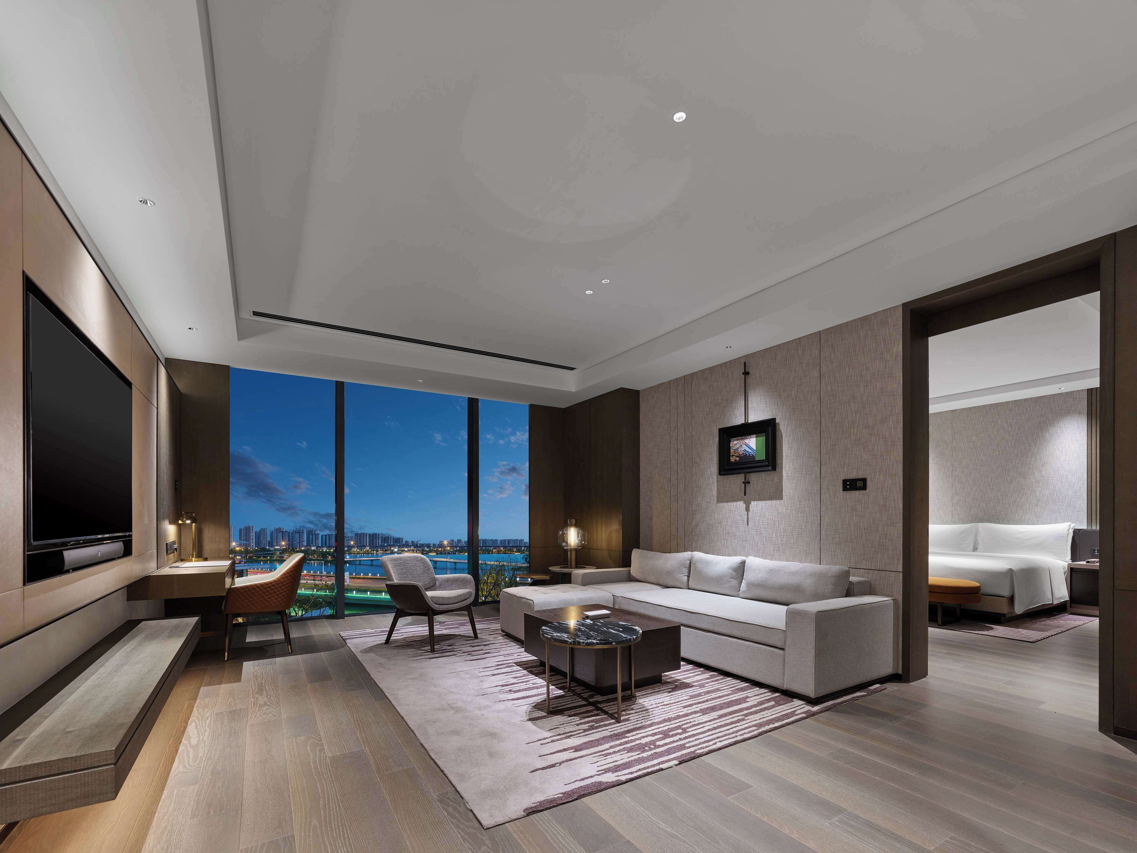 Suite Deluxe, 2 habitaciones | Zona de estar | Televisión de 65 pulgadas con canales por satélite