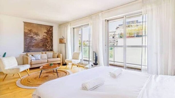 Una habitación de hotel con una cama grande, un sofá, una mesa de centro y un cuadro en la pared.